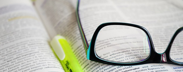 Libro con lentes y marcatextos encima. Imagen cortesía de Pixabay | Hans.